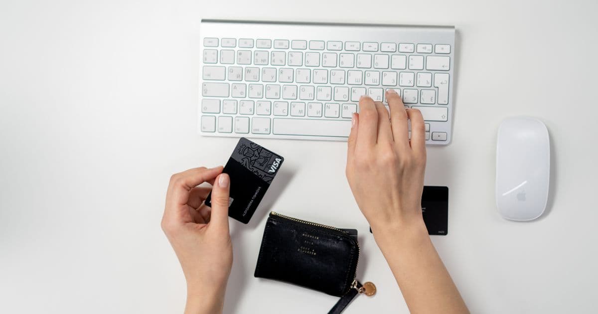 Persona pagando con tarjeta de forma segura junto a un teclado
